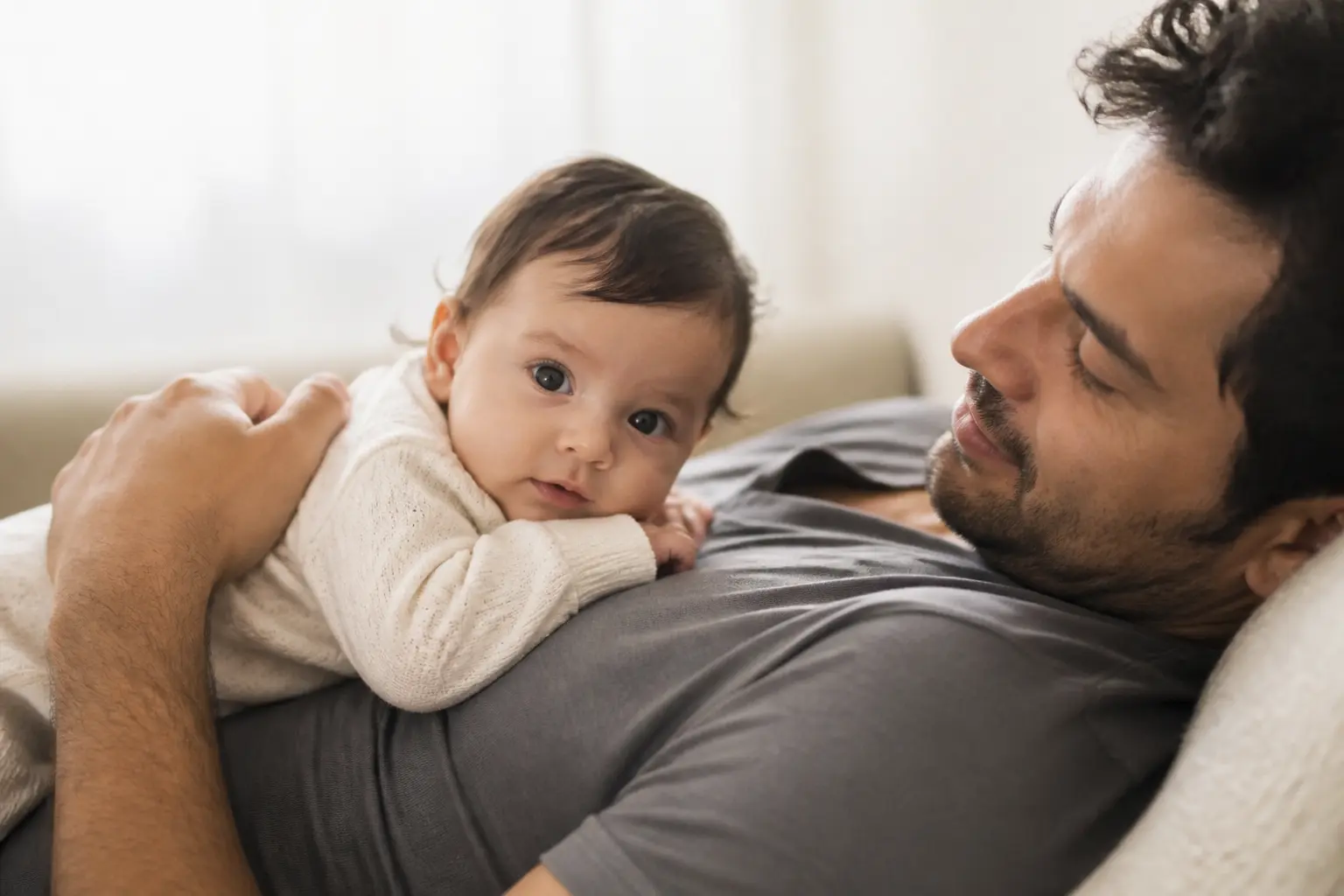 Tummy time quotidien : un parent soutient son bébé sur son torse, dans un moment calme et rassurant.