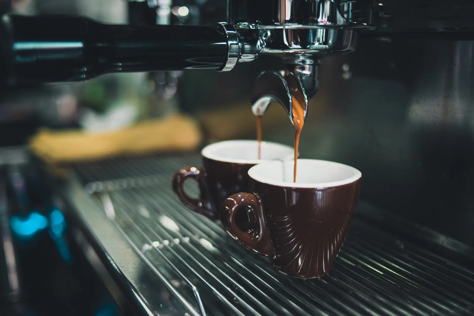 Double expresso qui coule dans deux tasses sous le percolateur