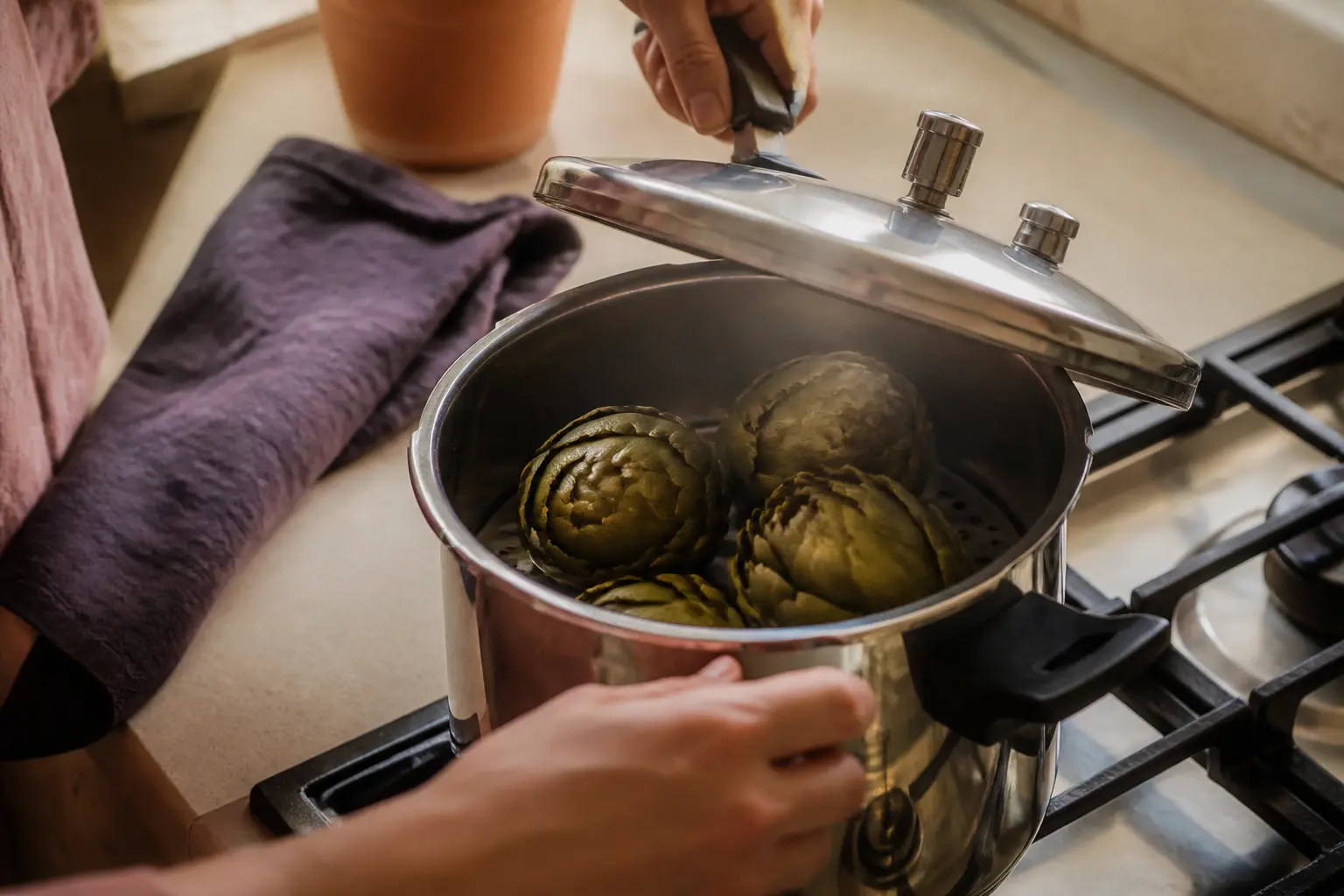 Cuisson artichaut cocotte minute dans une cuisine, artichauts en préparation dans une cocotte-minute sur le plan de travail.